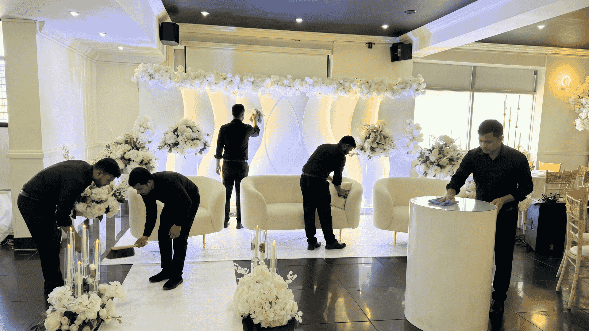 Blank canvas dry hire event venue being prepared for a wedding with tables, chairs, floral decorations, and catering setup